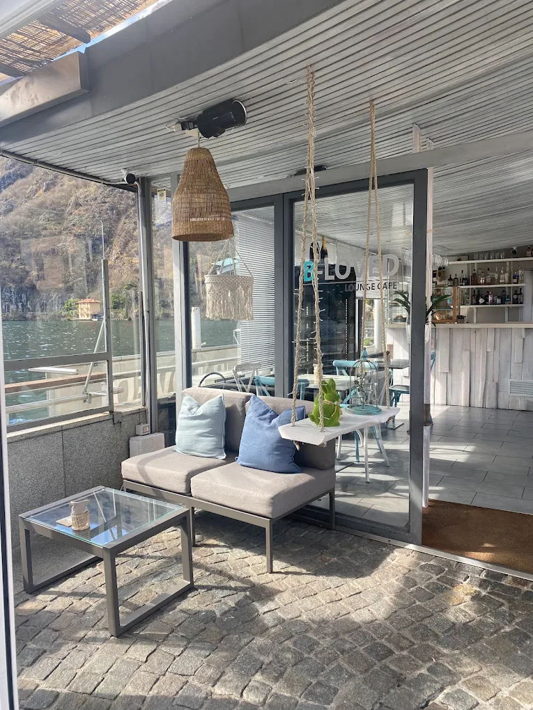 B-Loved Lounge Café — lakeside patio with lounge seating facing Lago di Lugano